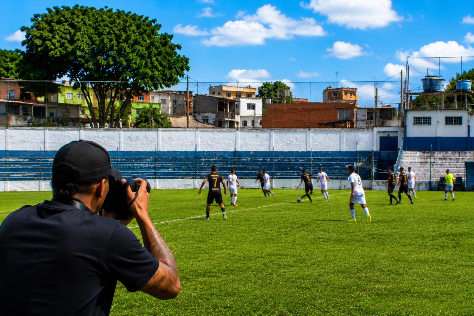 Fotógrafo registrando uma partida de futebol de várzea