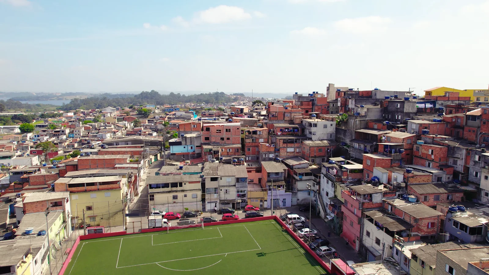 Campo de futebol cercado pelas casas da comunidade