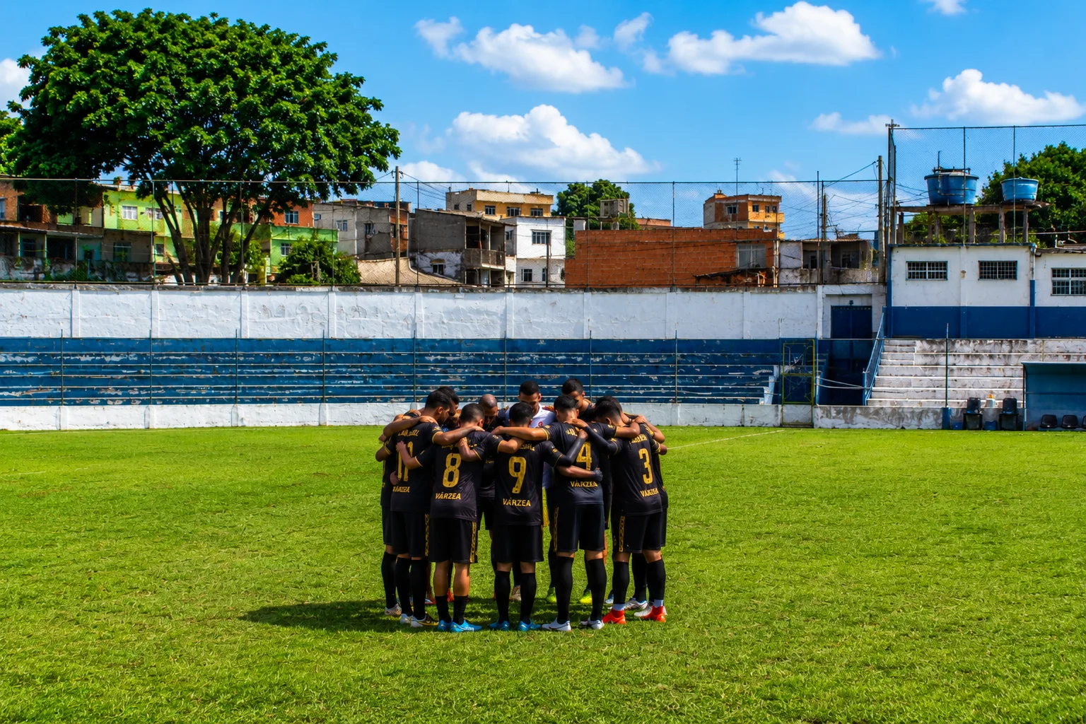 Jovens reunidos no campo de futebol da comunidade